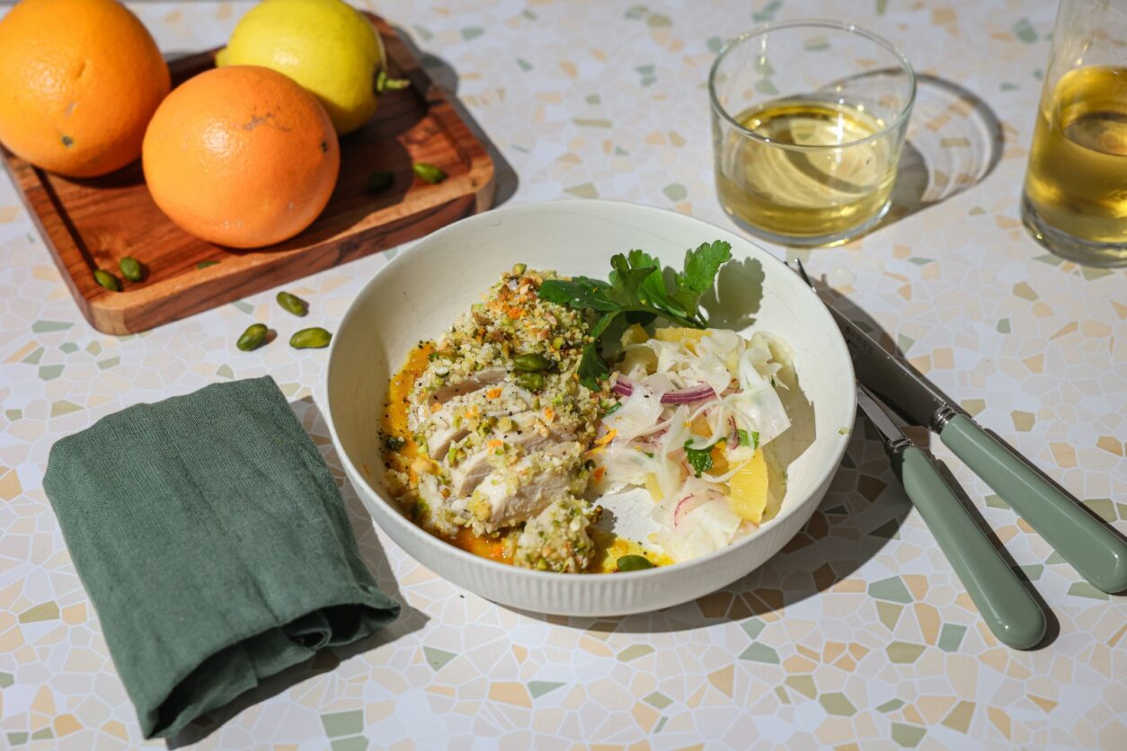 Ein Gericht aus Sizilien ist Hähnchen mit Pistazien-Mandel-Kruste und Safran-Orangen-Sauce, welches hier lecker präsentiert wird.