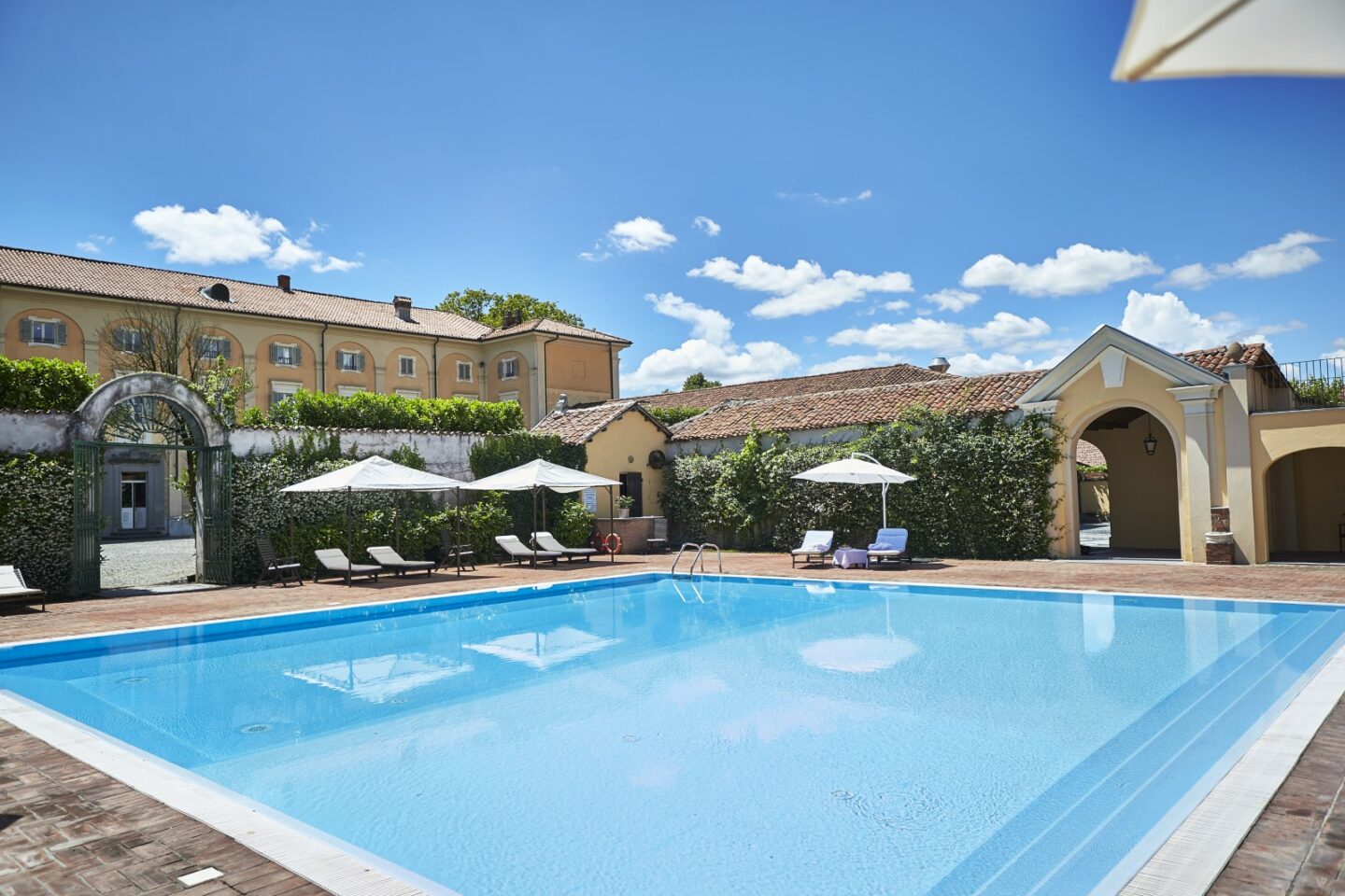 Blick über den großen Pool mit der prachtvollen Fassade der Villa im Hintergrund: Sina Villa Matilde - Boutiquehotel Romano Canavese