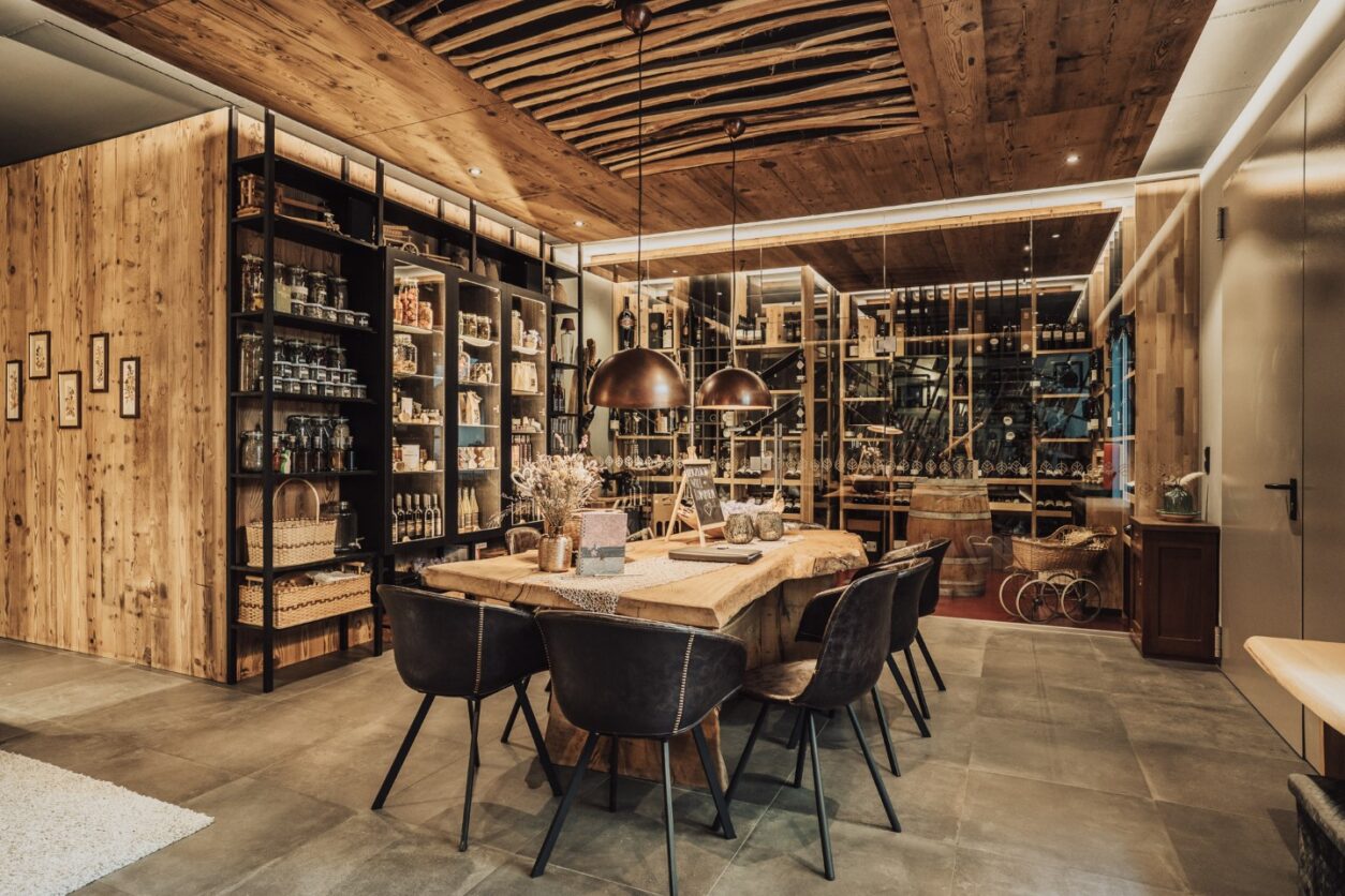 Blick in den Verkostungsraum des Pataunerhof mit Holztisch und Regalen mit Produkten aus eigener Herstellung
