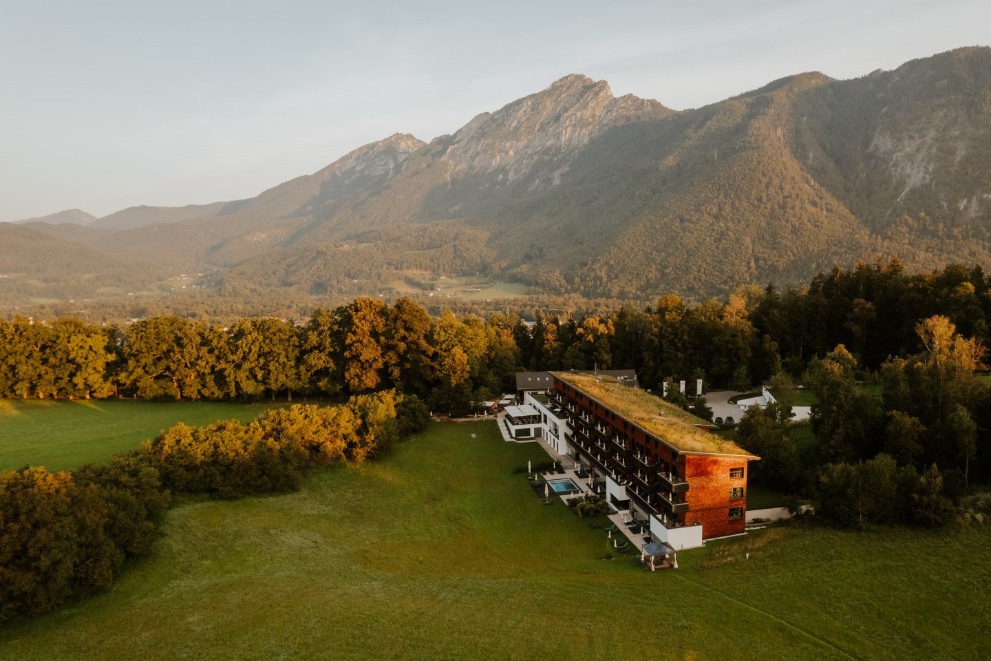 Luftaufnahme des Wellnesshotel Berchtesgadener Land Klosterhof inmitten von Grün vor imposanten Bergen